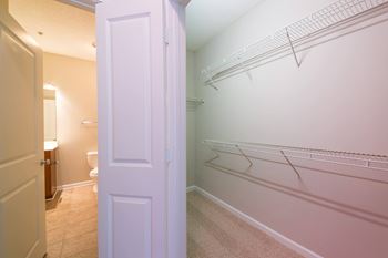 A white door is open to a hallway with a white wall and a white floor.